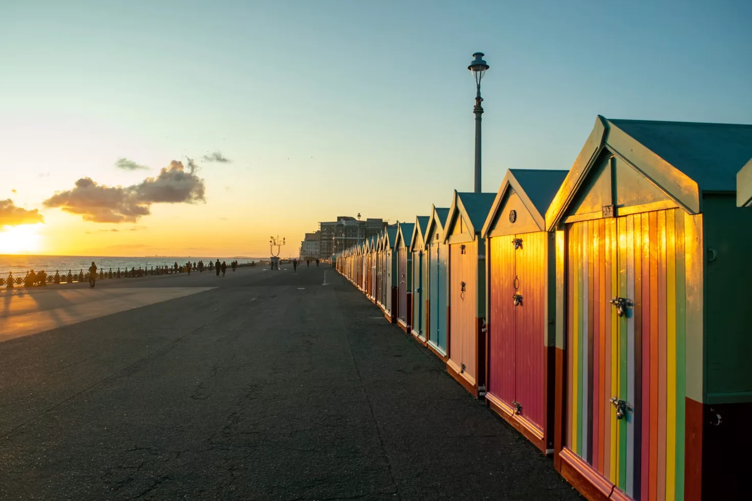 Colourful beach huts at sunset on the Brighton and Hove seafront, Sussex